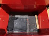 a red metal box with a black bag in it