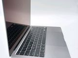 a silver laptop with a black keyboard on a white surface