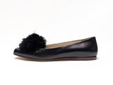 a black shoe with a pom pom on the top of it