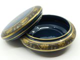 a blue and gold box with a lid on a white surface