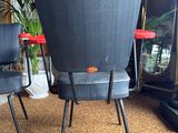 two black chairs sitting on top of a brown rug in a living room