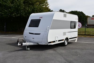 une photo d'un camping-car blanc garé sur un parking