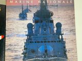 two books on a table with a picture of a ship in the background