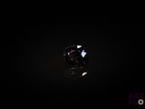 a close up of a black diamond on a black surface