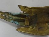 brass fish sculpture on a white surface with a white background