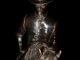 a statue of a man riding a horse with a hat on