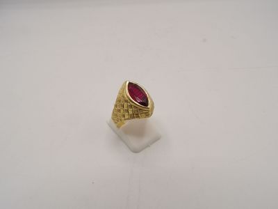 gros plan d'une bague en or avec une pierre rouge