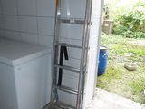 a ladder leaning against the wall next to a washer and dryer