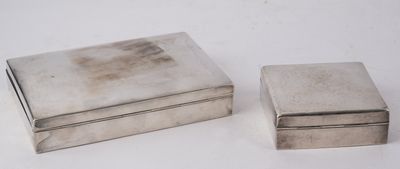 two silver boxes sitting next to each other on a white surface