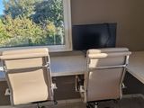 a desk with two chairs and a computer on it