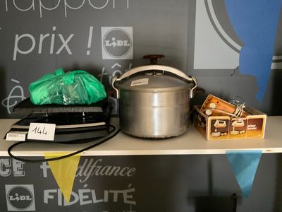 un pot en argent posé sur une étagère où se trouvent d'autres objets