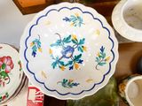 a white bowl with blue flowers on it sitting on a table