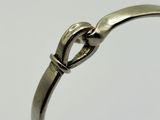 a close up of a silver ring with a knot on it