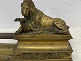 bronze statue of a lion resting on top of a wooden box