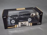 black die cast model of a car with a man in a suit in a box