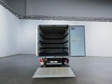 a white truck with its door open in a large room
