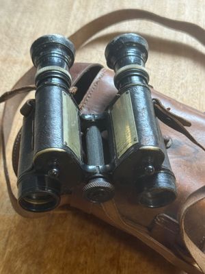 a pair of binoculars sitting on top of a brown bag