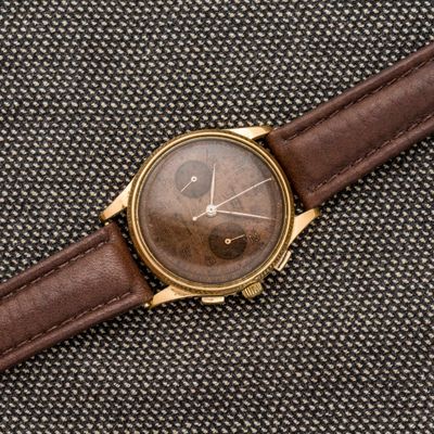 gros plan d'une montre-bracelet avec un bracelet en cuir marron