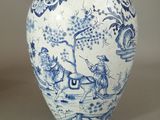 a blue and white vase with a picture of a man riding a horse
