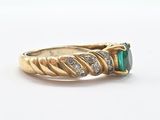 an image of a gold ring with a green stone