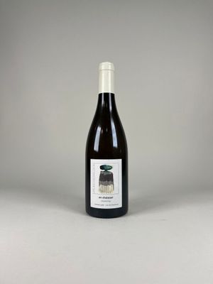une bouteille de vin posée sur une table blanche