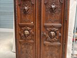 une armoire ancienne en bois avec des sculptures sur les portes