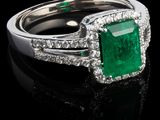 une bague en émeraude et diamant sur une surface noire
