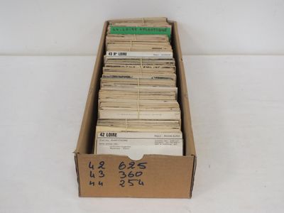 une boîte en carton ouverte, remplie d'une multitude de papiers, posée sur une surface blanche