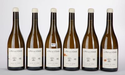six bottles of wine are lined up in a row on a table