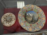 three plates on display in a glass case