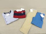 Trois paires de vêtements pour petit garçon sont posées sur un canapé