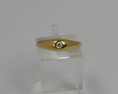 a gold ring with a diamond on top of a clear box