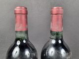 two bottles of wine sitting on top of a table next to each other