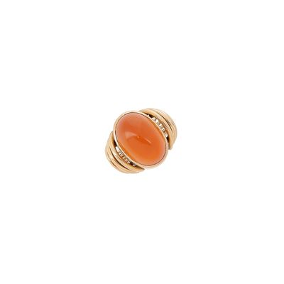 un gros plan d'une bague sertie d'une pierre orange