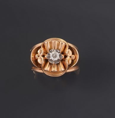 une bague en or avec un diamant au centre, sur un fond noir
