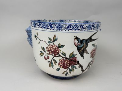 a blue and white bowl with a bird and flowers on it