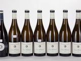 six bottles of wine are lined up in a row on a table