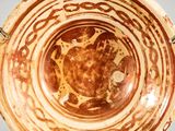 a brown and white bowl with designs on it