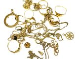 un tas de bijoux en or posés sur une surface blanche