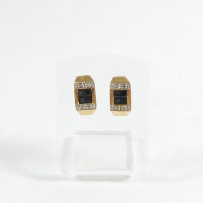 une paire de boucles d'oreilles noires et dorées ornées de diamants