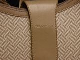 the back of a bag with a leather handle on a white background