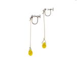 a pair of earrings with yellow beads on a white background