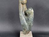 a sculpture of a woman holding a child on a marble base
