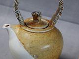 a brown and white teapot with a silver handle next to a brown and white teapot with a silver handle