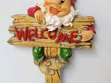 a wooden sign with a gnome holding a sign that says welcome