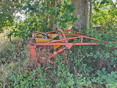 an old rusted out tractor in the middle of the woods