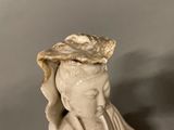 a statue of a woman with a hat on top of her head