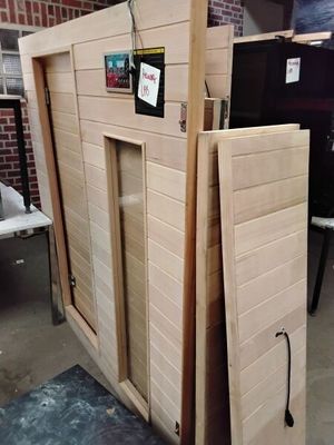 une photo d'un sauna en bois dont la porte est ouverte