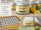 some jars of cream sitting on top of a table next to a box of flowers