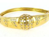 a close up of a gold bracelet with diamonds on it